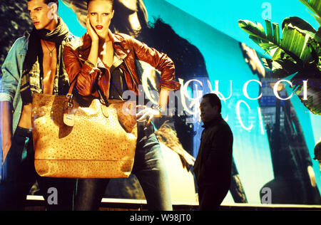 ------ Lokale chinesische Bewohner vorbei an einer Werbung für Gucci in Peking, China, 8. Februar 2011. China Capital hat im Freien verboten advertisi Stockfoto