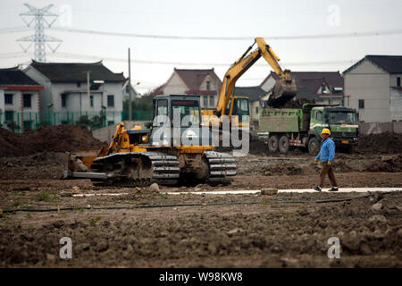 Ein chinesischer Wanderarbeiter Spaziergänge Vergangenheit Bau maschinen Arbeiten auf der Baustelle des Shanghai Disney Resort in Shanghai, China, 5 Decembe Stockfoto