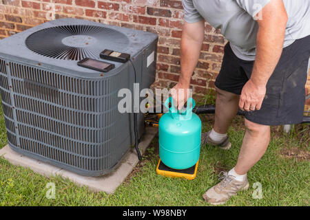 Air Conditioenr Wartungstechniker hinzufügen kühlend Stockfoto