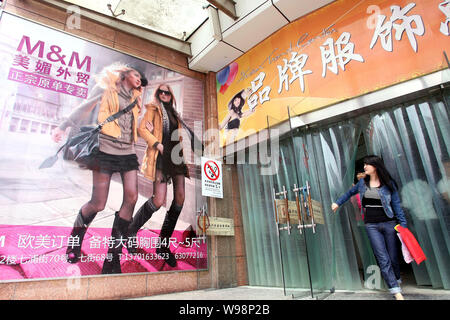 ------ Chinesische Kunden vorbei eine mode Werbung in einem Kleidung Mall auf Qipu Road in Shanghai, China, 5. Mai 2011. Shanghai Behörden sind Stockfoto