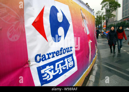 ------ Anwohner vorbei an einer Werbung für Carrefour in Shanghai, China, 17. Februar 2011. Europas größter Einzelhändler Carrefour am Dienstag Stockfoto