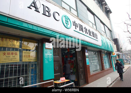 ---- Eine Frau geht über einen Zweig der ABC (Agricultural Bank of China) in Shanghai, China, 18. Februar 2011. Landwirtschaftlichen Bank von China Ltd., die n Stockfoto