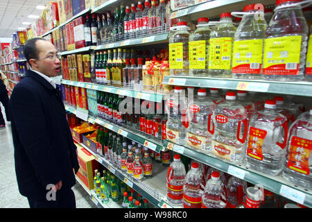 --FILE - ein chinesischer Kunde Geschäfte für Alkohol in einem Supermarkt in Shanghai, China, 21. Februar 2011. Mehr als 4 Milliarden Liter des weißen Geist Wir Stockfoto