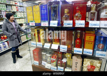 --FILE - ein chinesischer Kunde Geschäfte für Alkohol in einem Supermarkt in Shanghai, China, 4. Januar 2011. Mehr als 4 Milliarden Liter des weißen Geist waren Stockfoto