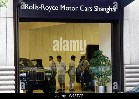 ------ Chinesische Autokäufer an einem Rolls-Royce Limousinen in der Rolls-Royce Showroom in Xintiandi in Shanghai, China, 27. Juli 2010. Sobald Rol Stockfoto