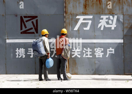 ---- Zwei Chinesische Wanderarbeiter abgebildet sind auf der Baustelle ein wohnprojekt von Vanke in Changchun Stadt entwickelt, im Nordosten Chi Stockfoto