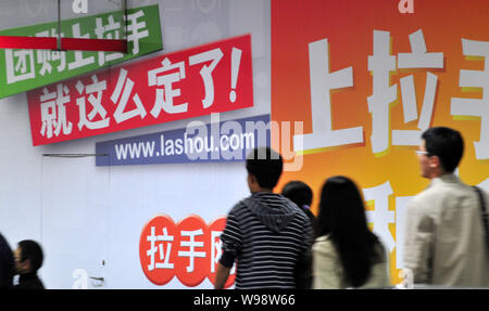 Anwohner vorbei an einer Werbung für online Group Buying Website lashou.com in Peking, China, 6. Oktober 2011. Lashou wird gesagt, die Ersten zu sein, Stockfoto