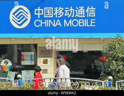 ---- Fußgänger vorbei an einem Zweig von China Mobile in Shanghai, China, 16. Januar 2010. Die Umfrage, die von der Werbung Riese WPP beauftragt, Berech Stockfoto