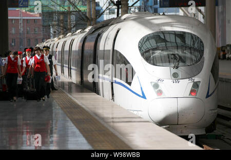 - - Datei - - CRH (China Railway High speed) die Mitarbeiter sind am Ende ihrer Schicht gesehen neben einem Bullet Zug am Bahnhof in Qingdao Qingdao Stockfoto