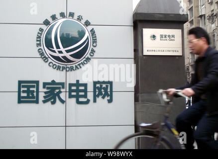 Ein chinesischer Mann reitet ein Fahrrad vorbei an einem Zweig der State Grid in Nanjing City, East China Jiangsu Provinz, 27. November 2010. Renaults Untersuchung ich Stockfoto