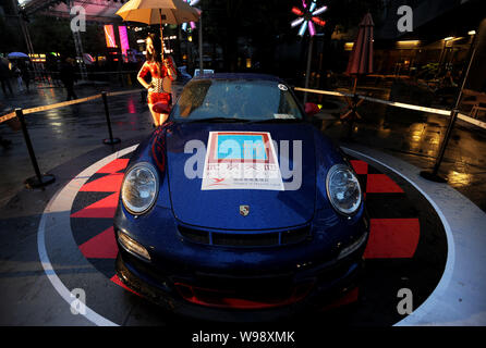 Ein Modell stellt bei einem Porsche Wagen an Xintiandi Plaza in Wuhan, China, Provinz Hubei, 30. September 2011. 50 Porsche Fahrzeuge wurden an Xintian geparkt Stockfoto