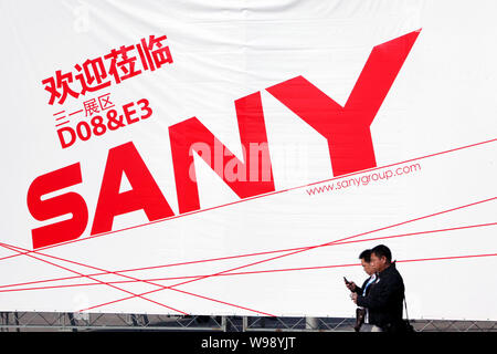 ---- Besucher vorbei an eine Werbung von SANY Heavy Industry Co., Muttergesellschaft von SANY Heavy Equipment International Holdings, während die 201 Stockfoto