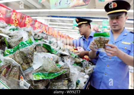 ------ Chinesische Polizeibeamte prüfen Klebreis Knödel in einem Supermarkt in Peking, China, 25. Mai 2011. China Gerichte haben Ord. Stockfoto