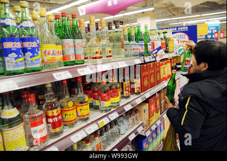 Ein chinesischer Kunde Geschäfte für Alkohol in einem Supermarkt in Shanghai, China, 1. März 2011. Mehr als 4 Milliarden Liter des weißen Geist wurden in C verkauft Stockfoto