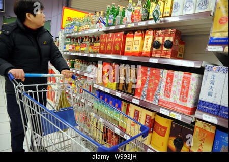 Ein chinesischer Kunde Geschäfte für Alkohol in einem Supermarkt in Shanghai, China, 1. März 2011. Mehr als 4 Milliarden Liter des weißen Geist wurden in C verkauft Stockfoto