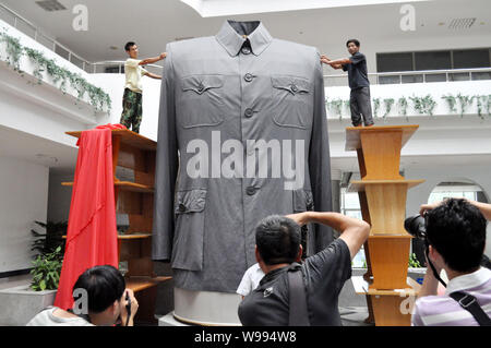 Arbeitnehmer einstellen, um einen riesigen chinesischen Tunika Anzug, auch als der Sun Yat-sen, während einer enthüllungsfeier an der Zhejiang Textil & Mode Hochschule in Ni bekannt Stockfoto