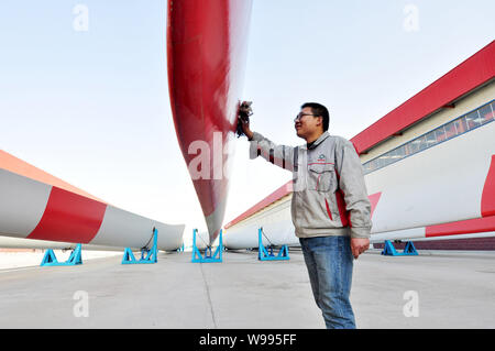---- Ein chinesischer Arbeiter wischt weg von Rotorblättern für Windenergieanlagen eine Fabrik in Zouping County, Binzhou City, East China Provinz Shandong, 16. März 2011. T Stockfoto