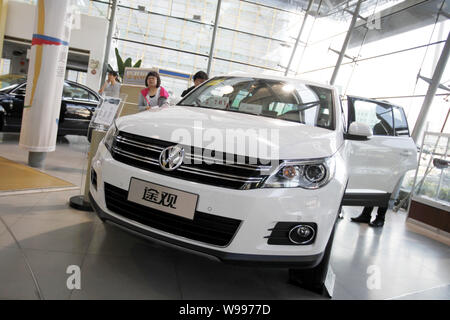 ------ Chinesischer Autokunden Blick an einem Volkswagen Tiguan bei einem Händler von Shanghai Volkswagen, ein Joint Venture zwischen der SAIC und VW in Shanghai, China Stockfoto