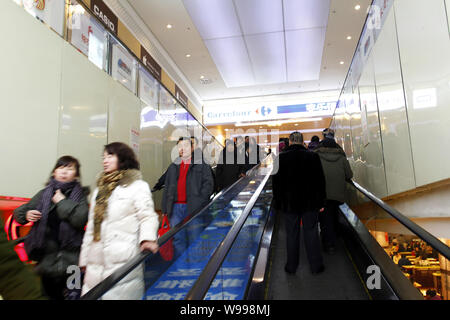 ------ Chinesische Kunden Rolltreppen nehmen Einkauf in einem Supermarkt Carrefour in Changchun Stadt zu gehen, im Nordosten Chinas in der Provinz Jilin, 24. Januar 201 Stockfoto