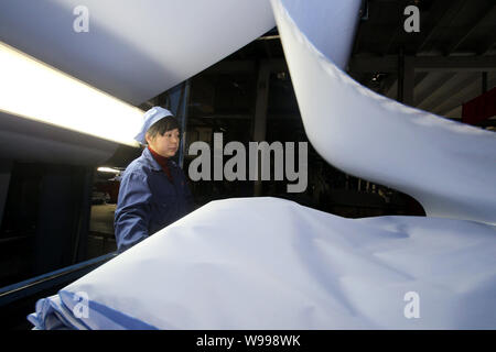 ---- Eine weibliche chinesischer Arbeiter überwacht die Produktion von Tuch in der Fabrik von Jiangsu Lianfa Textile Co., Ltd. in Haian Grafschaft, Nantong City, Eas Stockfoto