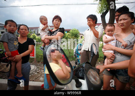 Chinesische Eltern halten ihre Kinder nach ihnen, in eine Kindertagesstätte, wo ein Mitarbeiter 8 Kinder mit einem Messer in Shanghai, China, 29. August verletzt Stockfoto