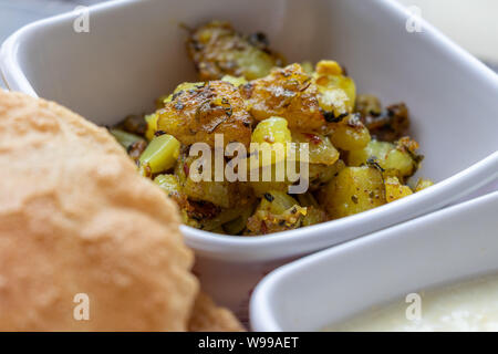 Puri Bhaji, Masala Aloo Sabzi Braten mit gebratenen Puri oder indisches Brot und Quark serviert, selektive konzentrieren. Stockfoto