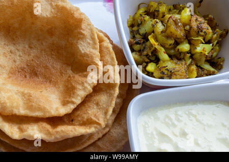Puri Bhaji, Masala Aloo Sabzi Braten mit gebratenen Puri oder indisches Brot und Quark serviert. Stockfoto