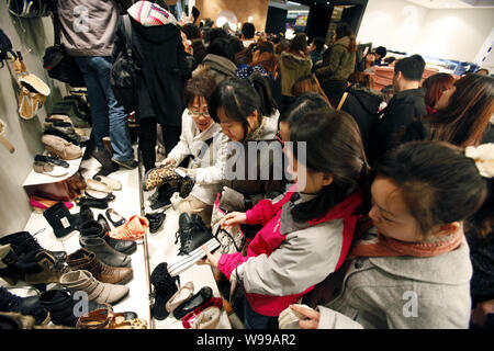 ------ Chinesische Kunden kaufen Schuhe im Verkauf bei einer Shopping Mall in Shanghai, China, 2. Dezember 2011. China Verbraucherpreisindex (VPI), ein Manometer Stockfoto
