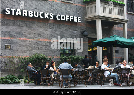 - - - - Kunden sind an einem Starbucks Coffee Store in Shanghai, China, 7. Oktober 2011 gesehen. Starbucks Coffee Company hat weitere fünf neue Chi eingegeben Stockfoto