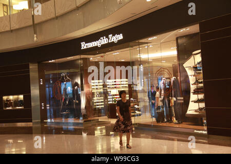 ---- Eine chinesische Frau geht hinter einem Flagship Store von Ermenegildo Zegna, Shanghai, China, 6. September 2010. Einer der größten Ermenegildo Zegnas hurdl Stockfoto