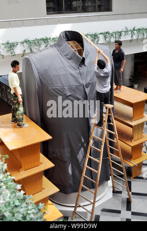 Arbeitnehmer einstellen, um einen riesigen chinesischen Tunika Anzug, auch als der Sun Yat-sen, während einer enthüllungsfeier an der Zhejiang Textil & Mode Hochschule in Ni bekannt Stockfoto