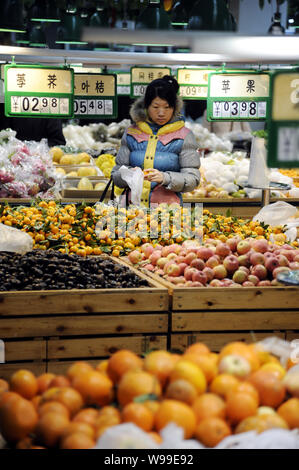 --FILE - ein chinesischer Kunde Geschäfte für Früchte in einem Supermarkt in Zibo City, East China Provinz Shandong, 27. Februar 2011. China Verbraucherpreis in Stockfoto