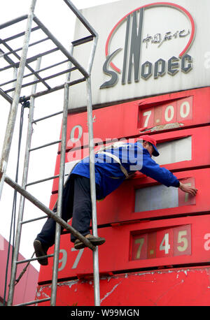 Ein chinesischer Arbeiter aktuelles Treibstoffpreise an einer Tankstelle von Sinopec in Kunshan City, Central China Provinz Hubei, 20. Februar 2011. China, Asias bigg Stockfoto