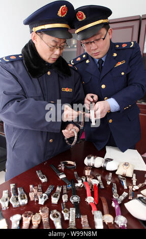 ------ Chinesische Polizeibeamte gefälschte Uhren in einem Geschäft in Shenyang konfiszieren, Nordosten China Liaoning Province, 23. März 2011. Der Senat Stockfoto