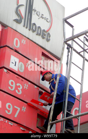 Ein chinesischer Arbeiter aktuelles Treibstoffpreise an einer Tankstelle von Sinopec in Kunshan City, Central China Provinz Hubei, 20. Februar 2011. China, Asias bigg Stockfoto