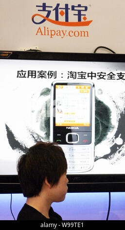 ---- Ein anwohner an einer fördernden stand der online Zahlung Betreiber Alipay.com in Peking, China, 27. April 2011. Alibaba Group Holdin Stockfoto