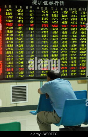 Ein Chinesischer Investor schaut bei Aktienkursen (grün für Preis fallend) an einem Lager Brokerhaus in Dalian in der Provinz Liaoning im Nordosten Chinas, 13 Septem Stockfoto