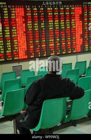 Ein Chinesischer Investor schaut bei Aktienkursen (grün für Preis fallend) an einem Lager Brokerhaus in Dalian in der Provinz Liaoning im Nordosten Chinas, 30 Septem Stockfoto