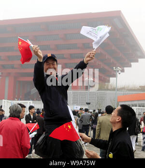 Ein Besucher Wellen chinesischen Nationalflagge und Shanghai Expo Fahnen vor der China Pavillon an der World Expo in Shanghai, China, 20. April 2010 Stockfoto