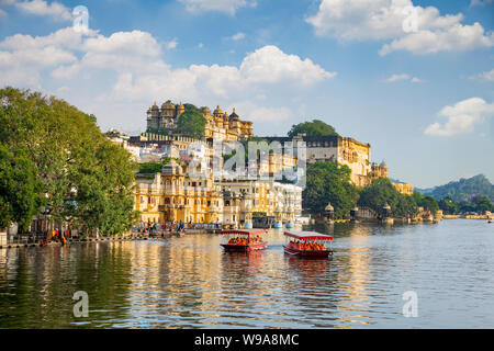 City Palace und touristische Bootsfahrt auf dem Pichola-See. Udaipur, Rajasthan, Indien Stockfoto