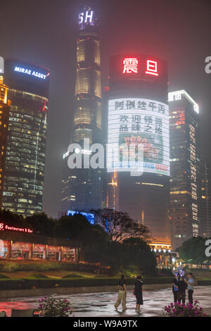 Shanghai Tower hoch über den Bund Boardwalk in Pudong, China auf einer nebligen Nacht. Stockfoto