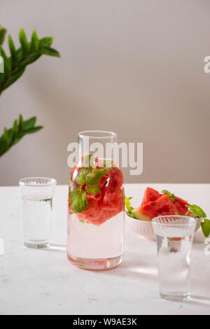 Wassermelone Getränk in Glas mit Scheiben Wassermelone auf weißem Hintergrund Stockfoto