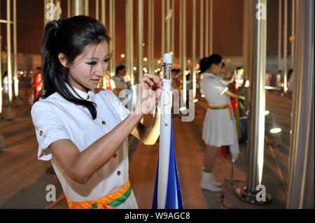 Expo Personal haul nationale Flaggen der Länder in der Shanghai Expo teilnehmen, nach der Schließung der Weltausstellung Expo 2010 im Expo Park in Stockfoto