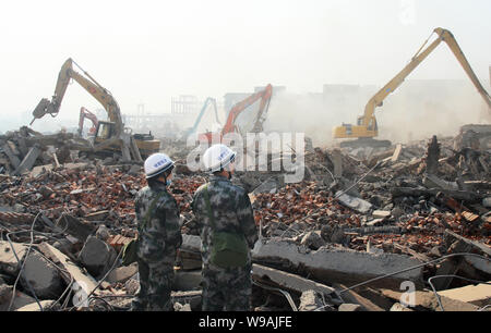 ------ Chinesische Polizeibeamte watch die erzwungene Abbruch von angeblich illegal gebauten Häusern in Wuhan City, Central China Provinz Hubei, Stockfoto