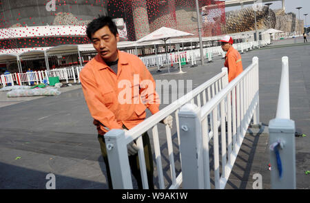 Chinesische Arbeiter Zäune vor den Schweizer Pavillon an der Weltausstellung in Shanghai, China, 1. November 2010 auseinander. Shanghai ist jetzt Stockfoto