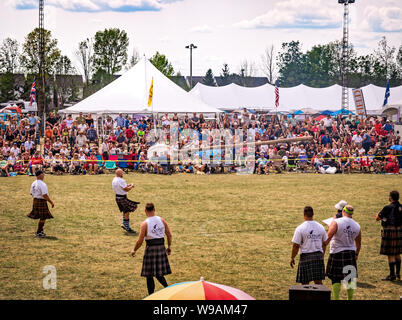 Fergus, Ontario, Kanada - 08 11 2018: Traditionelle schottische heavies Wettkämpfe Athleten mit Kilt ist Beweis für seine Fähigkeiten in einer Caber Toss Conte Stockfoto