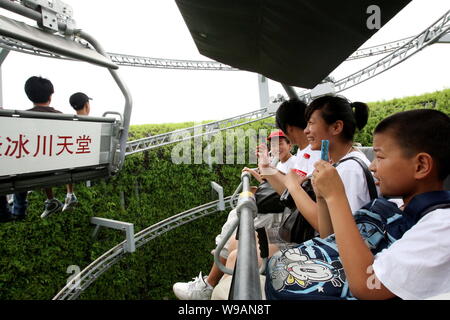 Besucher sitzen auf dem Berg Titlis Sessellifte in der Schweiz Pavillon auf der Weltausstellung in Shanghai, China, 10. Juli 2010. Stockfoto