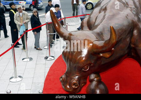 Lokale chinesische Bewohner schauen Sie sich die Bronze Bund Stier Statue, entworfen von Italienisch-amerikanische Künstler Arturo di Modica, am Bund in Shanghai, China, 15. Stockfoto