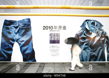 Ein chinesischer Mann Vergangenheit eine Anzeige für Lücke in Shanghai, China, 24. Oktober 2010. Uns Textileinzelhändler Lücke wird zwei Filialen in Shanghai geöffnet, auf Stockfoto