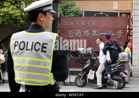 Ein chinesischer Polizist wacht vor einer Grundschule in Shanghai, China, 6. Mai 2010. China verstärkt Sicherheitskräfte zu gewährleisten. Stockfoto